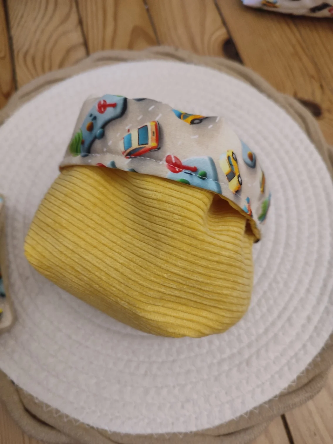 panier tissus Mini Drive de couleur jaune tissu côtelé avec une tissu motif voiture et route vue de côté sur un tapis beige