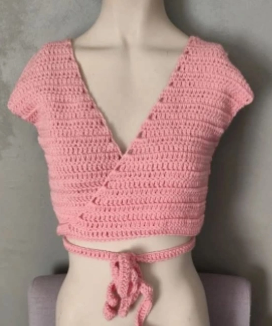 cache coeur fait en crochet de couleur rose clair sur un mannequin