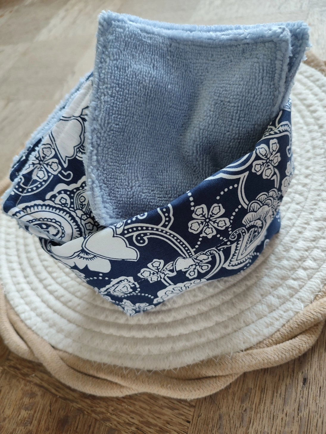 panier et lingettes tissu bambou bleu ciel et tissus Bandana Navy de couleur bleu foncé avec motif blanc sur un tapis beige