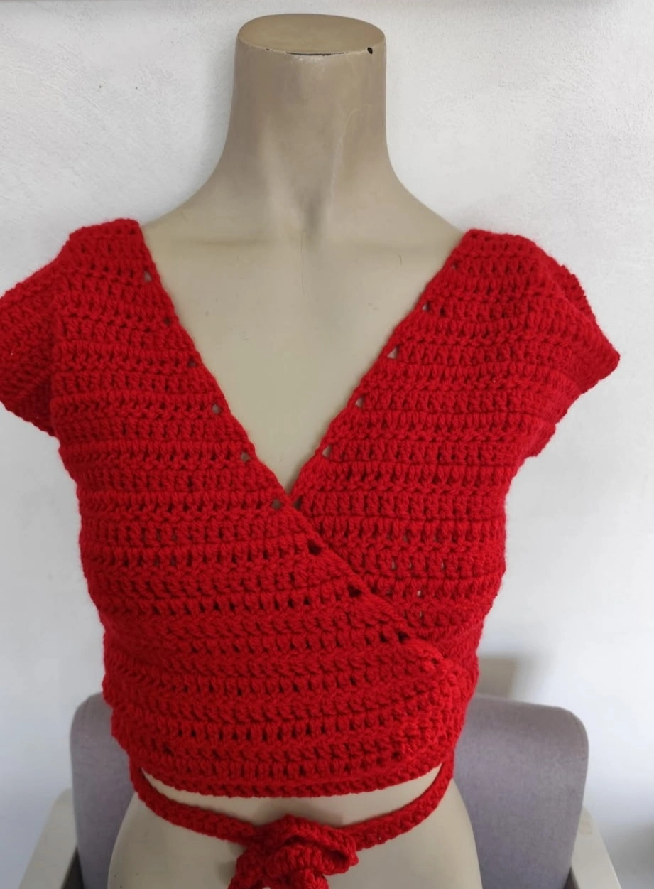 cache coeur fait en crochet de couleur rouge clair sur un mannequin