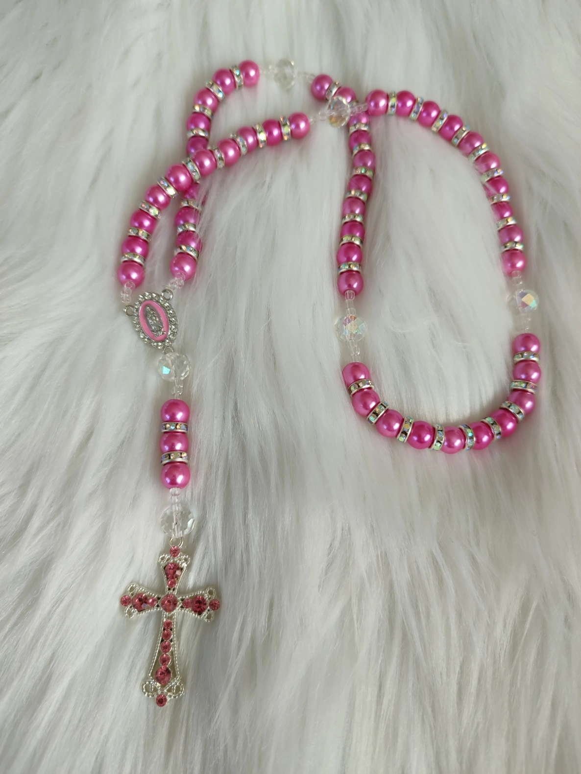 Chapelet "Perle de grâce" fait avec des perles rose foncé et blanche transparente, des perles séparatrice blanche et une croix rose foncé