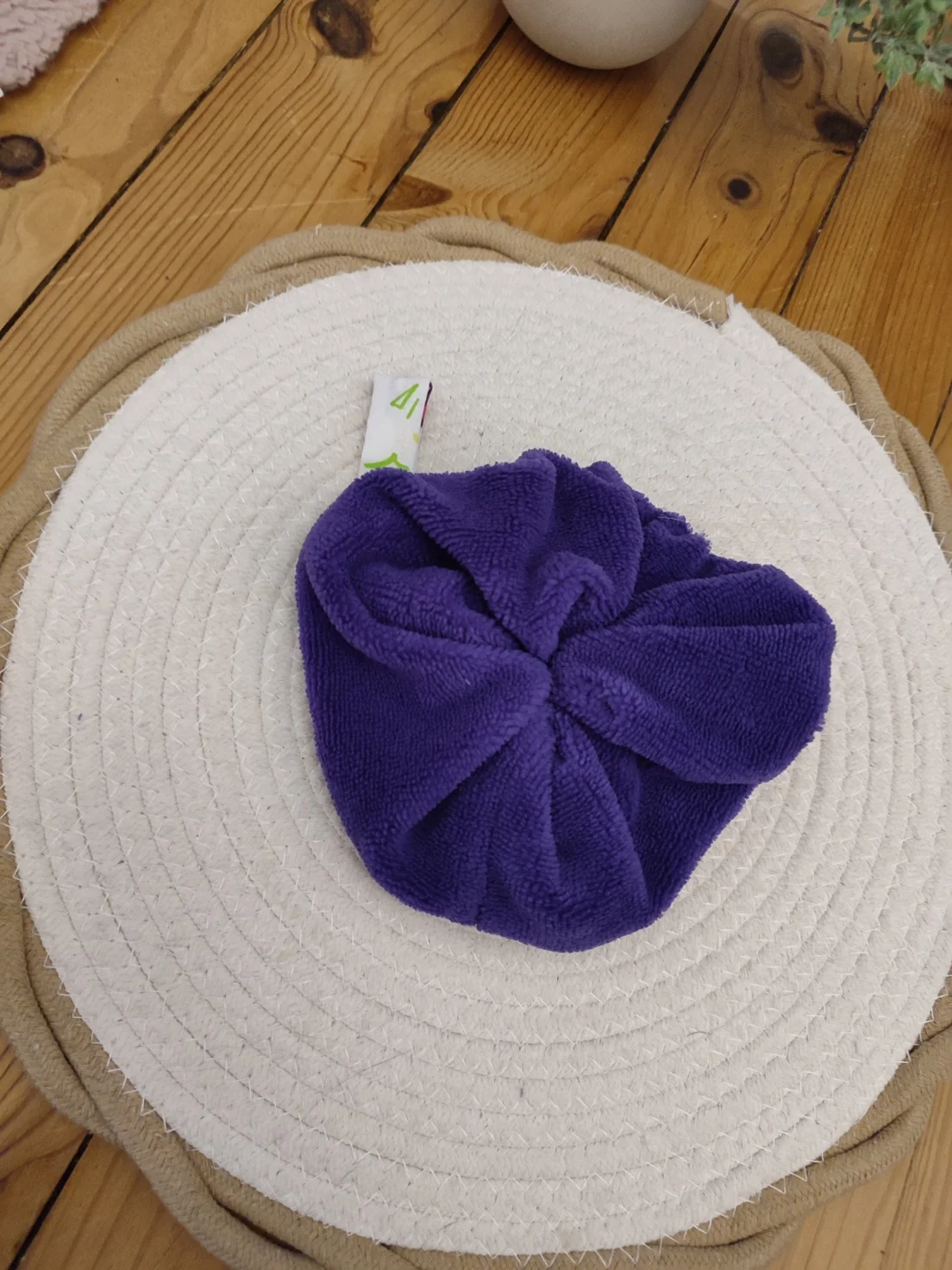 Fleur de douche fait avec un tissu bambou violet sur un tapis beige