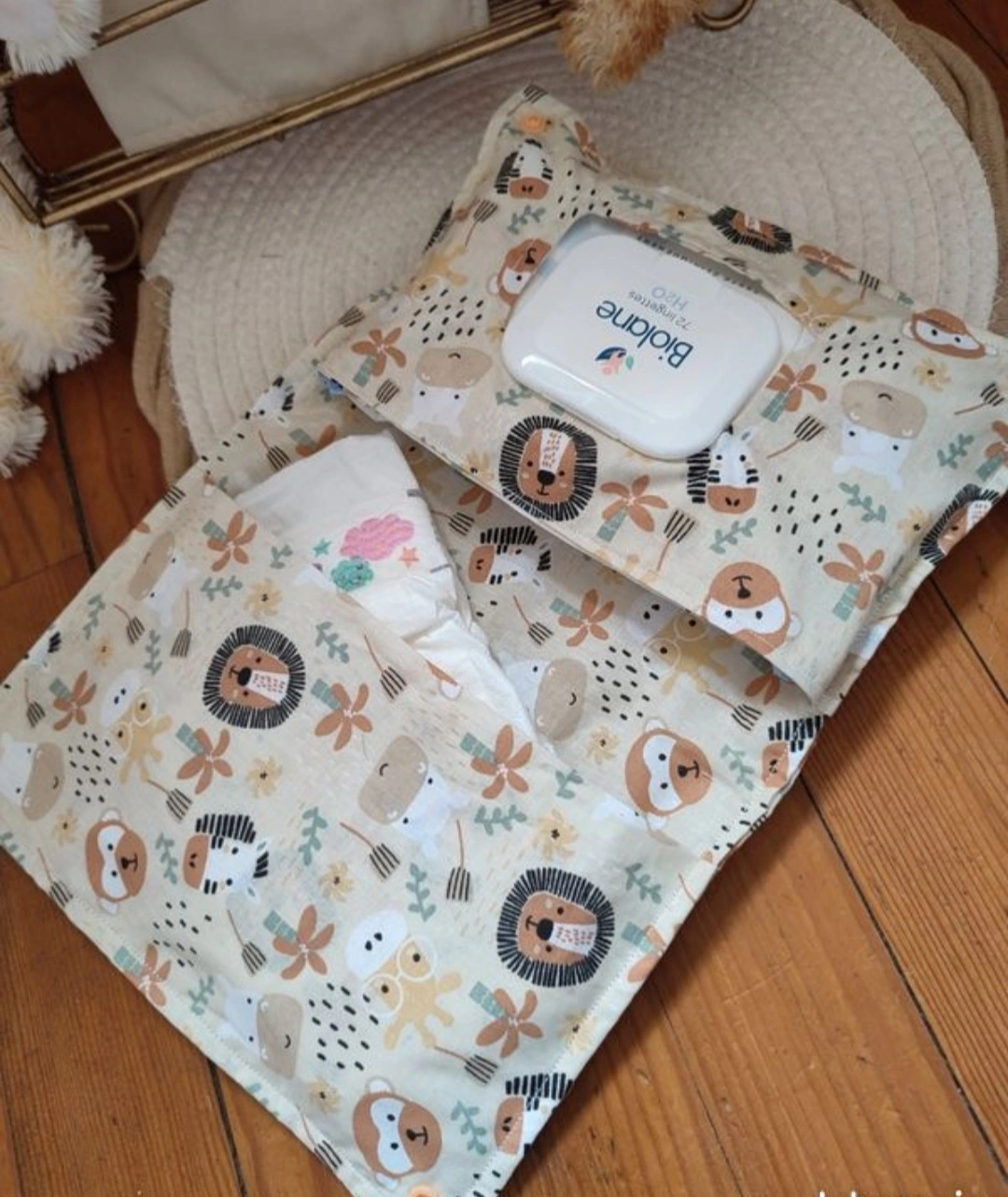 pochette à lange artisanale ouverte, elle est de couleur beige avec des motifs d'animaux de la jungle