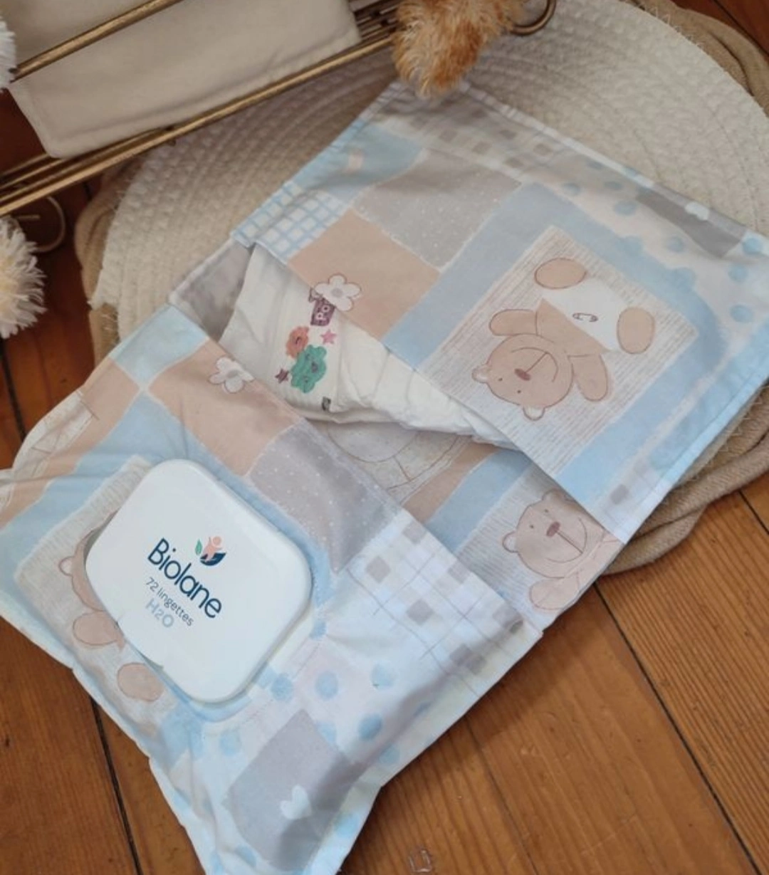 pochette à lange artisanale ouverte, elle est de couleur bleu claire avec des motifs d'ourson en couche
