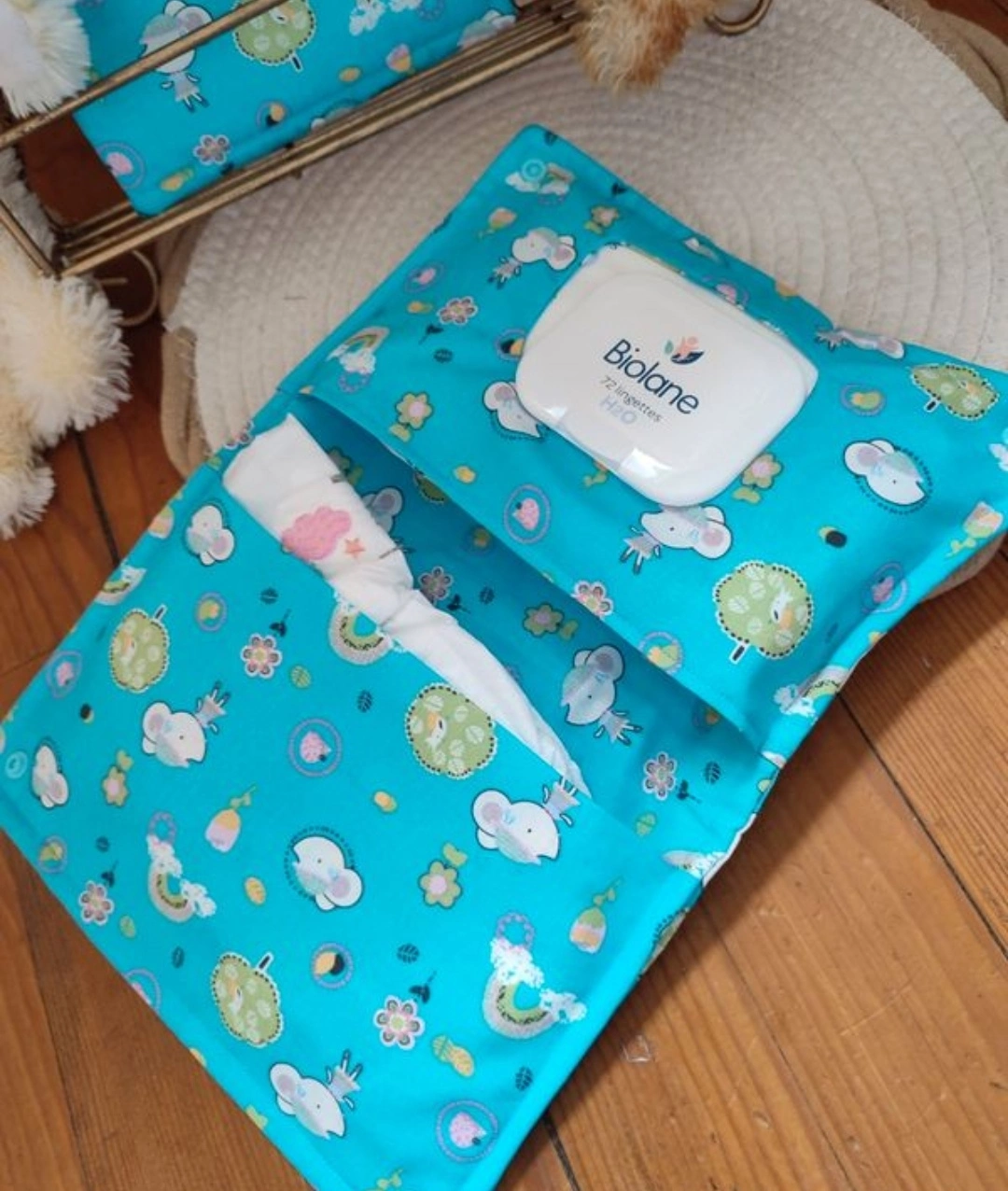 pochette à lange artisanale fait main ouverte, elle est de couleur bleu avec des motifs de souris blanche