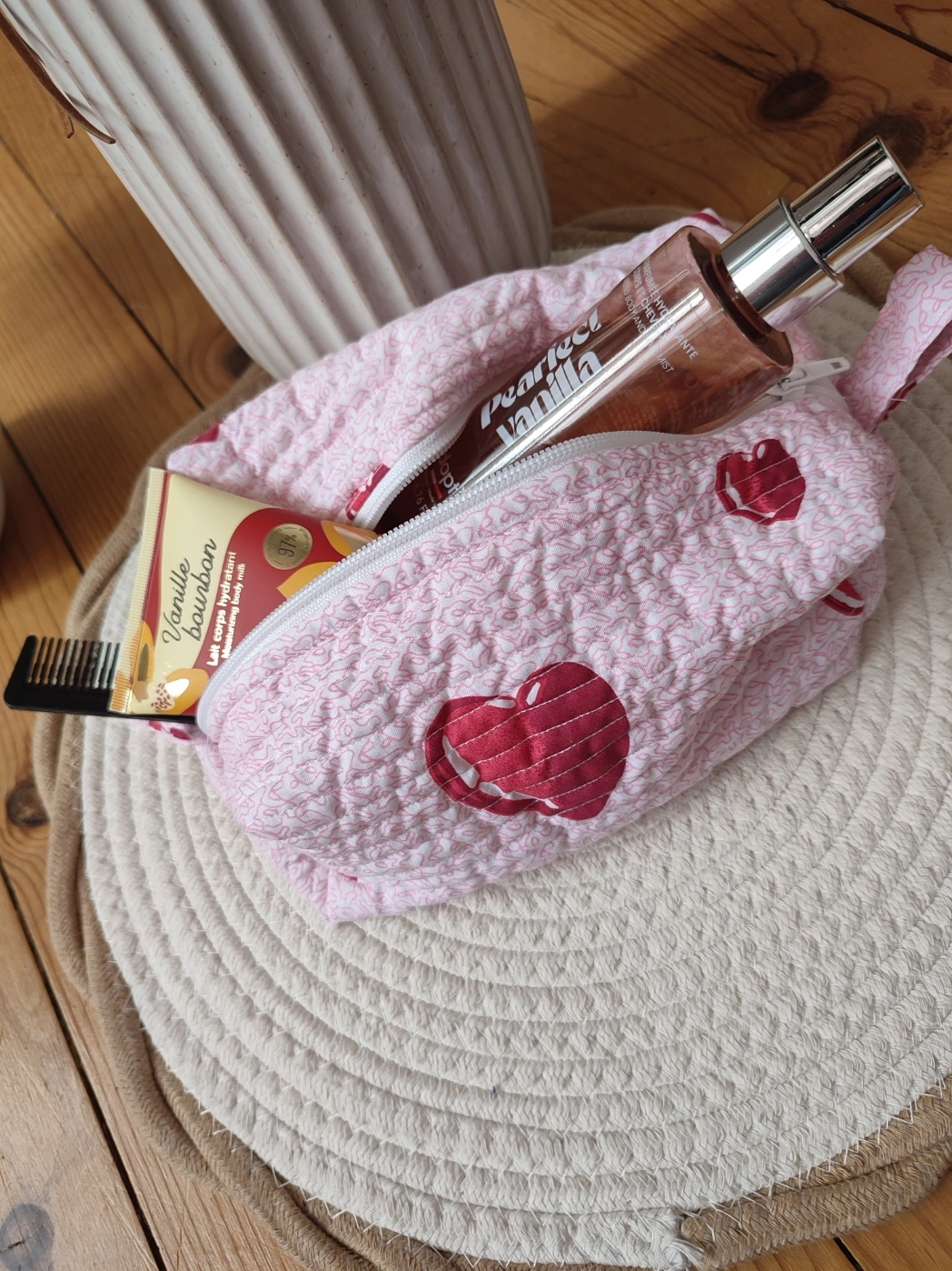 trousse de toilette de la collection Coeur avec motif de coeur rouge vu du dessous ouverte avec des produit dedans