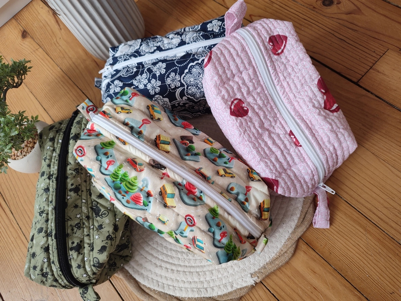 Plusieurs trousse de toilette des collections City Drive, Bandana, Coeur vues du dessus sur un tapis beige