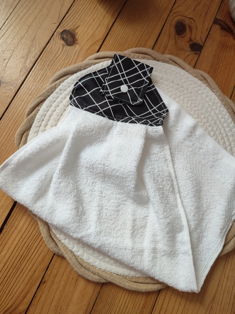 vu d'un essui main de couleur noir et avec motif de trait blanc et de sa serviette de couleur blanche pliée en deux