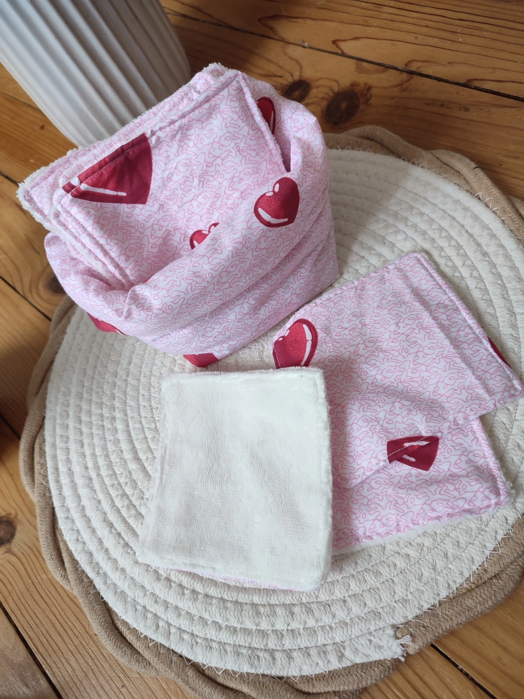 panier et lingettes tissus Coeur de couleur rose clair avec motif de coeur rouge et un tissu bambou de couleur beige sur un tapis beige
