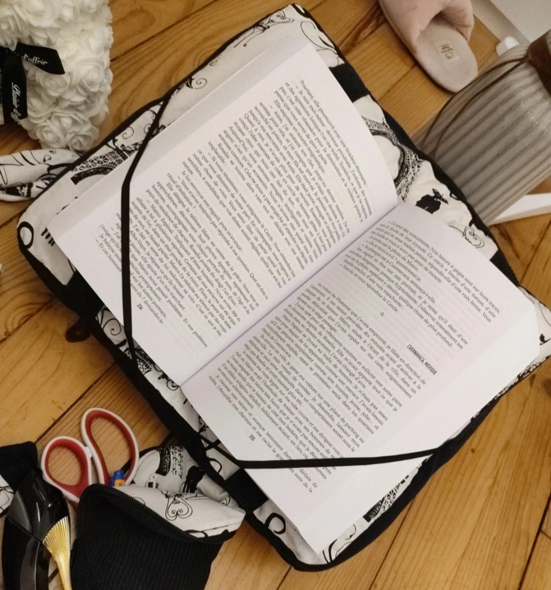 Coussin de lecture Les pages de Paris fait main avec un tissu côtelé noir et un tissu avec des des motifs de la ville de Paris noir sur fond blanc avec un livre ouvert vue de haut