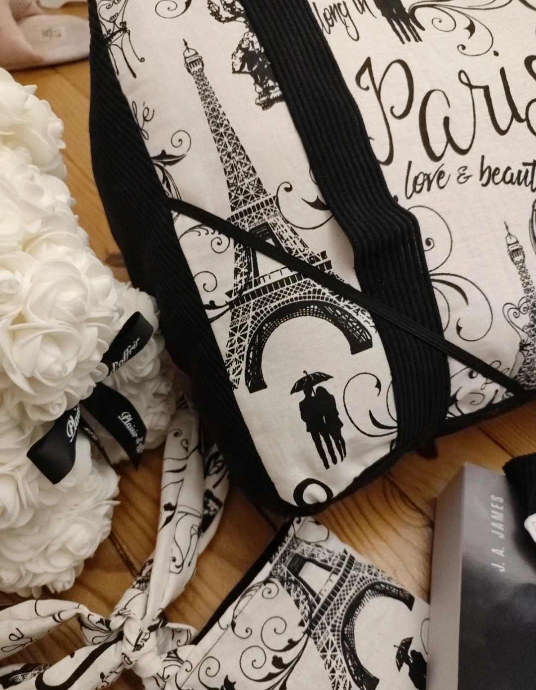 Coussin de lecture Les pages de Paris fait main avec un tissu côtelé noir et un tissu avec des des motifs de la ville de Paris noir sur fond blanc vue du coin