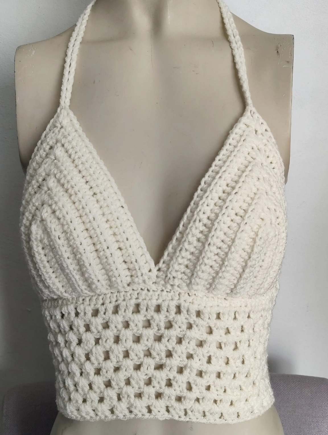 Top coquillage couleur blanc cassé sur un mannequin