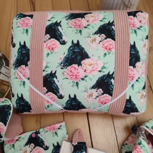 Coussin de lecture Douce évasion fait main avec un tissus côtelé rose et un tissus avec des motifs de chevaux noir et des rose de couleurs rose sur un fond vert d'eau