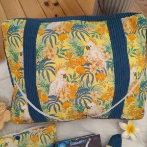 Coussin de lecture Lagon bleu fait main avec un tissu côtelé colvert et un tissu avec des motifs de cacatoès et de fleurs tropical sur fond jaune vue de haut