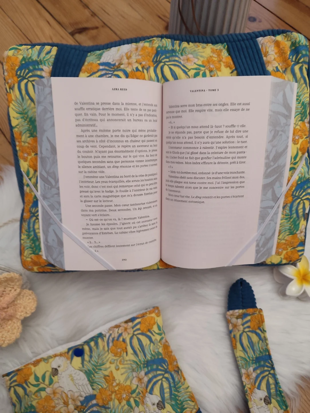 Coussin de lecture Lagon bleu fait main avec un tissu côtelé colvert et un tissu avec des motifs de cacatoès et de fleurs tropical sur fond jaune avec un livre ouvert