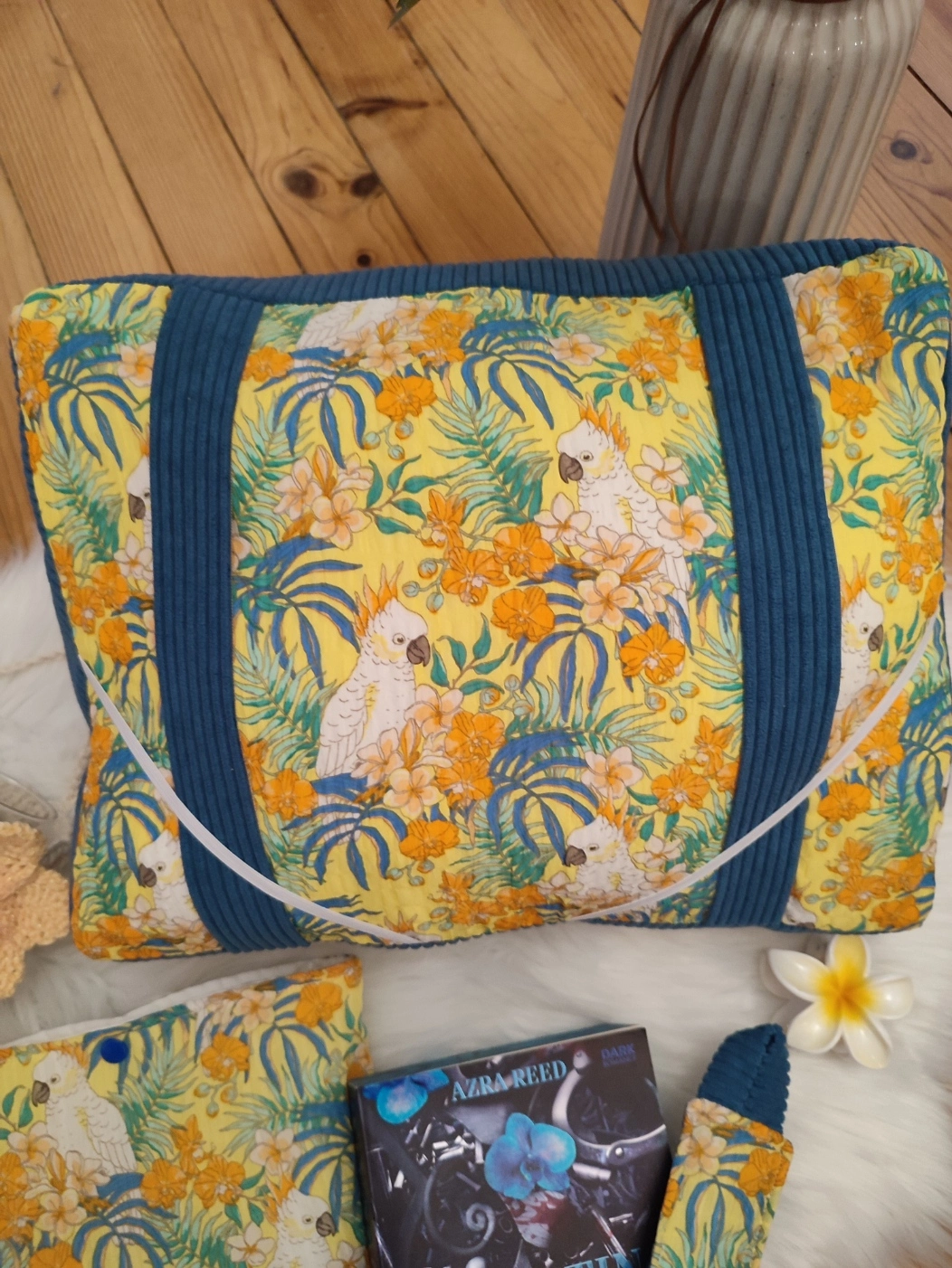 Coussin de lecture Lagon bleu fait main avec un tissu côtelé colvert et un tissu avec des motifs de cacatoès et de fleurs tropical sur fond jaune vue de haut