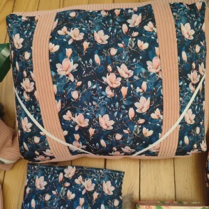 Coussin de lecture Magnolia nocturne fait main avec un tissus côtelé vieux rose et les fleurs de magnolia sur fond bleu marine