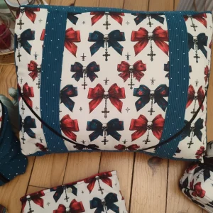 Coussin de lecture Nuit de velours fait main avec un tissus côtelé de couleur colvert et un tissus avec des têtes de mort, des noeuds de couleurs rouge et colvert sur fond blanc