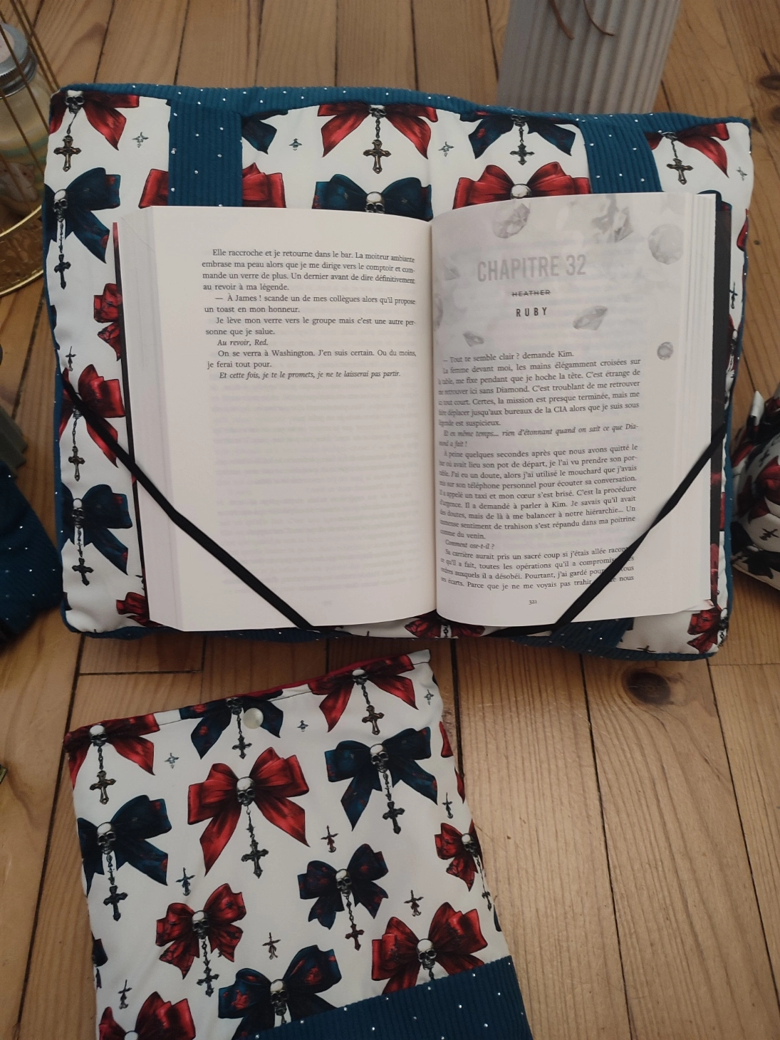 Coussin de lecture Nuit de velours fait main avec un tissus côtelé de couleur colvert et un tissus avec des têtes de mort, des noeuds de couleurs rouge et colvert sur fond blanc avec un livre ouvert