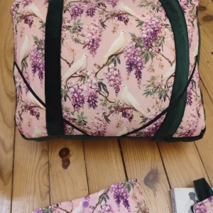 Coussin de lecture Sous les glycines fait main avec un tissus velours de couleur vert foncé et un tissus avec des fleurs de glycines et des colombes sur fond rose