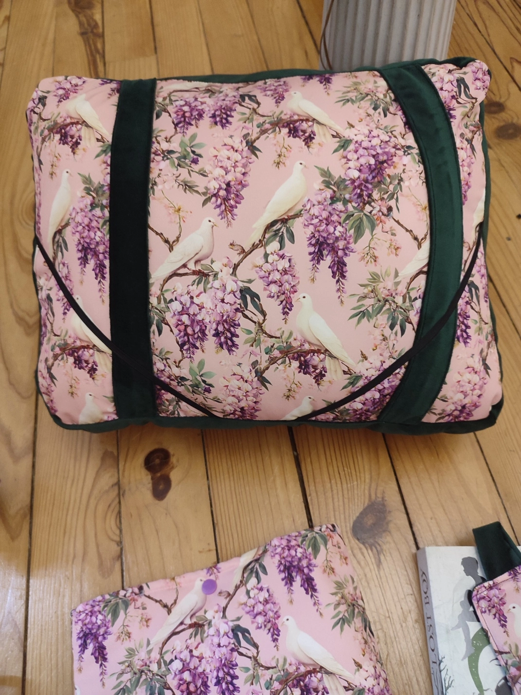 Coussin de lecture Sous les glycines fait main avec un tissus velours de couleur vert foncé et un tissus avec des fleurs de glycines et des colombes sur fond rose