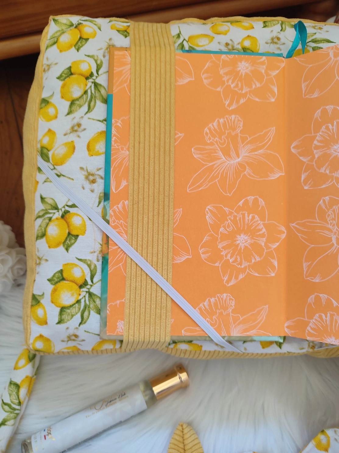 Coussin de lecture Citron fait main avec un tissu côtelé jaune et un tissu avec des motifs de citron sur fond blanc vue avec la page de garde d'un livre
