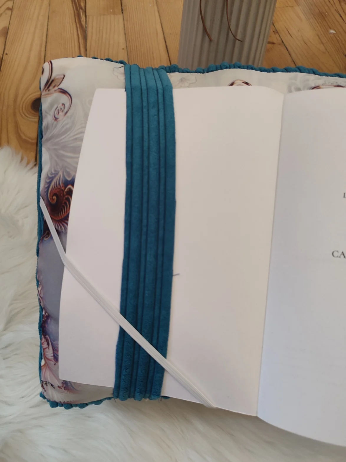 Coussin de lecture vue avec une page de garde Jardin d'azur fait main avec un tissus côtelé bleu et des motifs volet et bleu