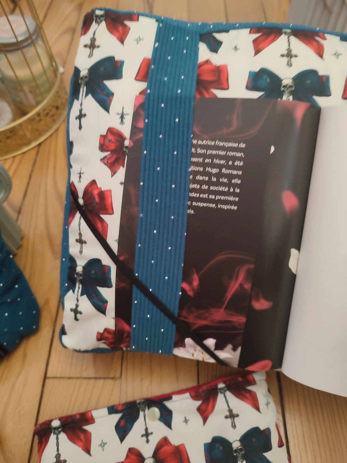 Coussin de lecture Nuit de velours fait main avec un tissus côtelé de couleur colvert et un tissus avec des têtes de mort, des noeuds de couleurs rouge et colvert sur fond blanc avec la page de garde d'un livre