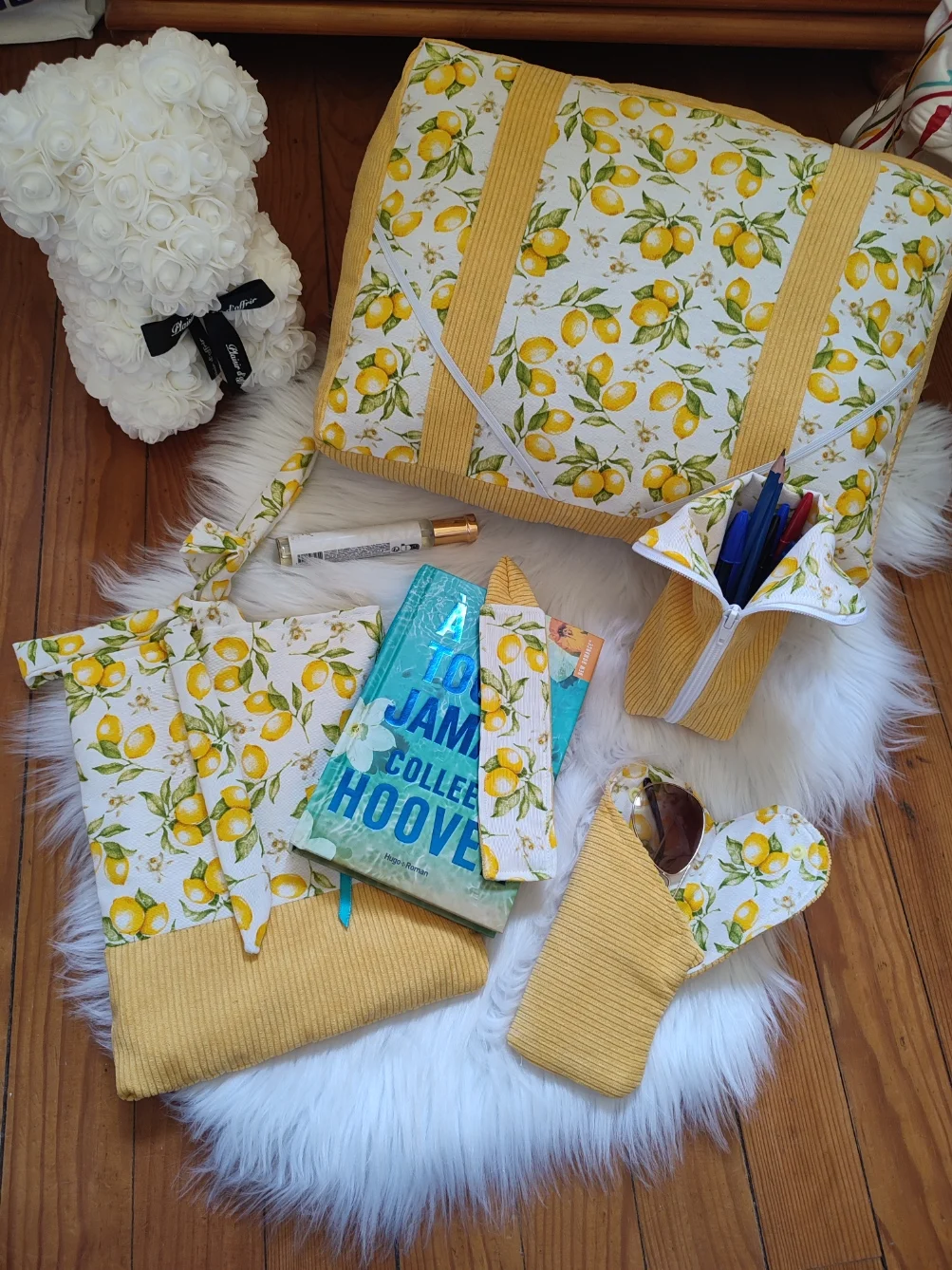 Ensemble de lecture Citron fait main avec un tissu velours jaune et un tissu avec des motifs de citron sur fond blanc vue de haut comprenant le coussin de lecture, la trousse, le chouchou, le marque page et la pochette à livre