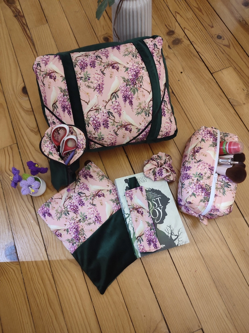 Ensemble de lecture Sous les glycines fait main avec un tissus velours de couleur vert foncé et un tissus avec des fleurs de glycines et des colombes sur fond rose comprenant le coussin de lecture, la pochette à livre, la trousse de toilette, le chouchou, la trousse et le marque page