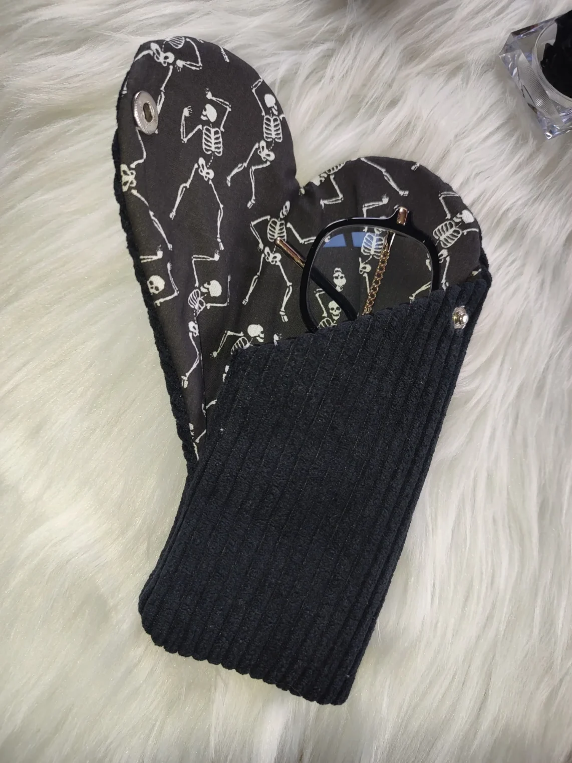 Etui à lunette confectionner avec un tissu côtelé noir pour l'extérieur et un tissu avec de squelette qui dansent