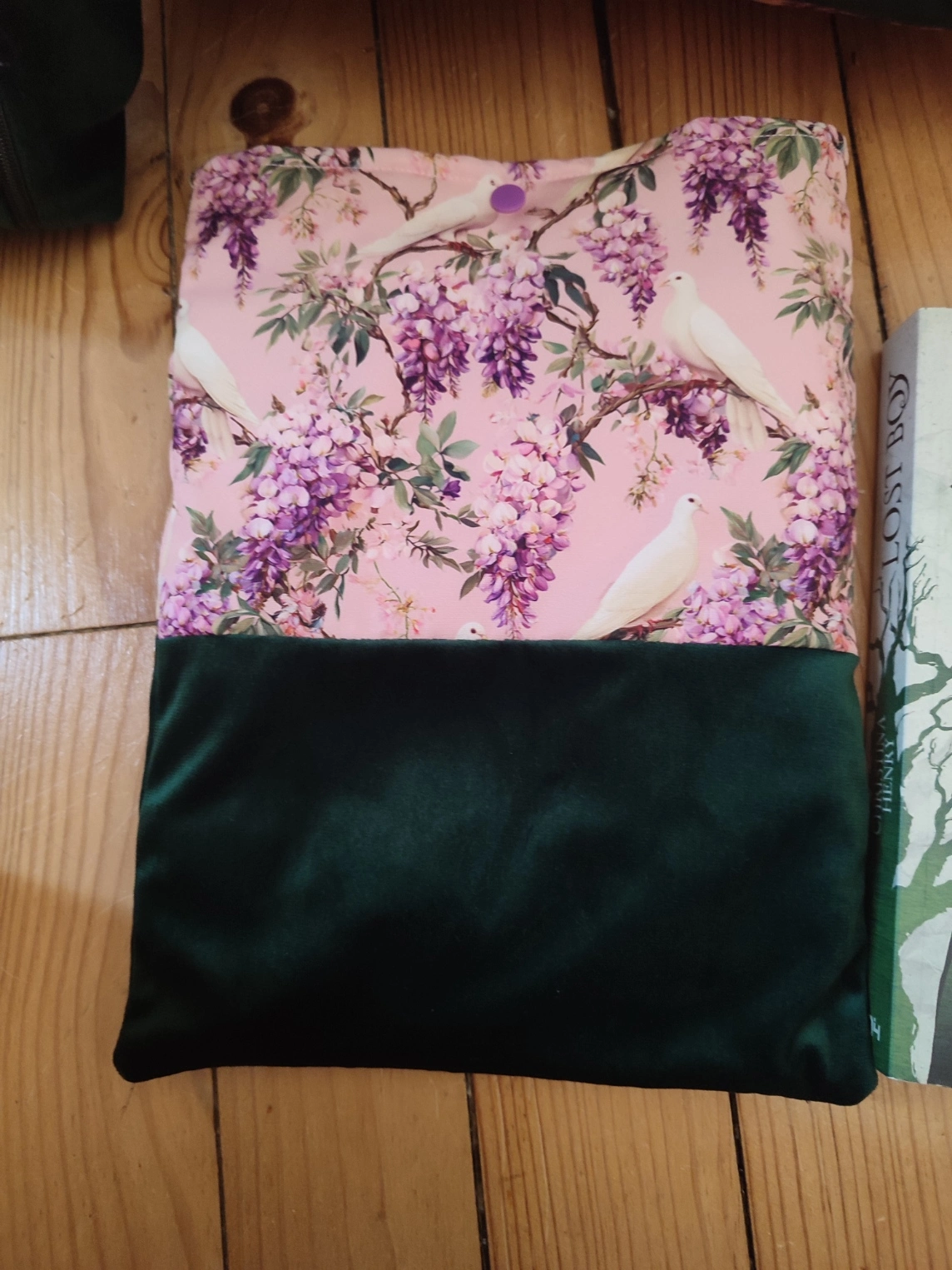 Pochette à livre Sous les glycines fait main avec un tissus velours de couleur vert foncé et un tissus avec des fleurs de glycines et des colombes sur fond rose vu
