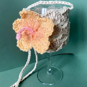 Porte verre en crochet de couleur beige avec une fleur d'hibiscus