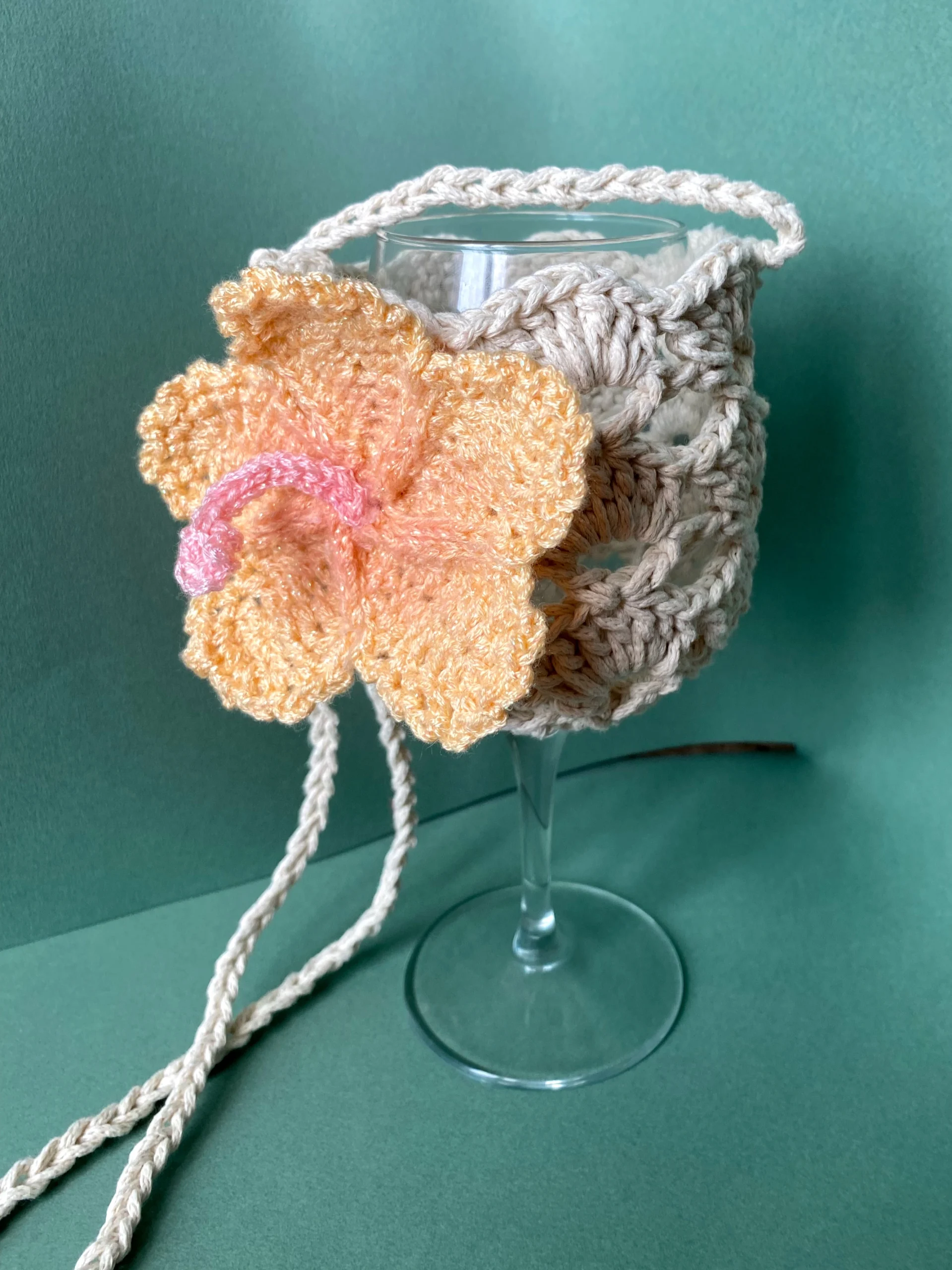 Porte verre en crochet de couleur beige avec une fleur d'hibiscus