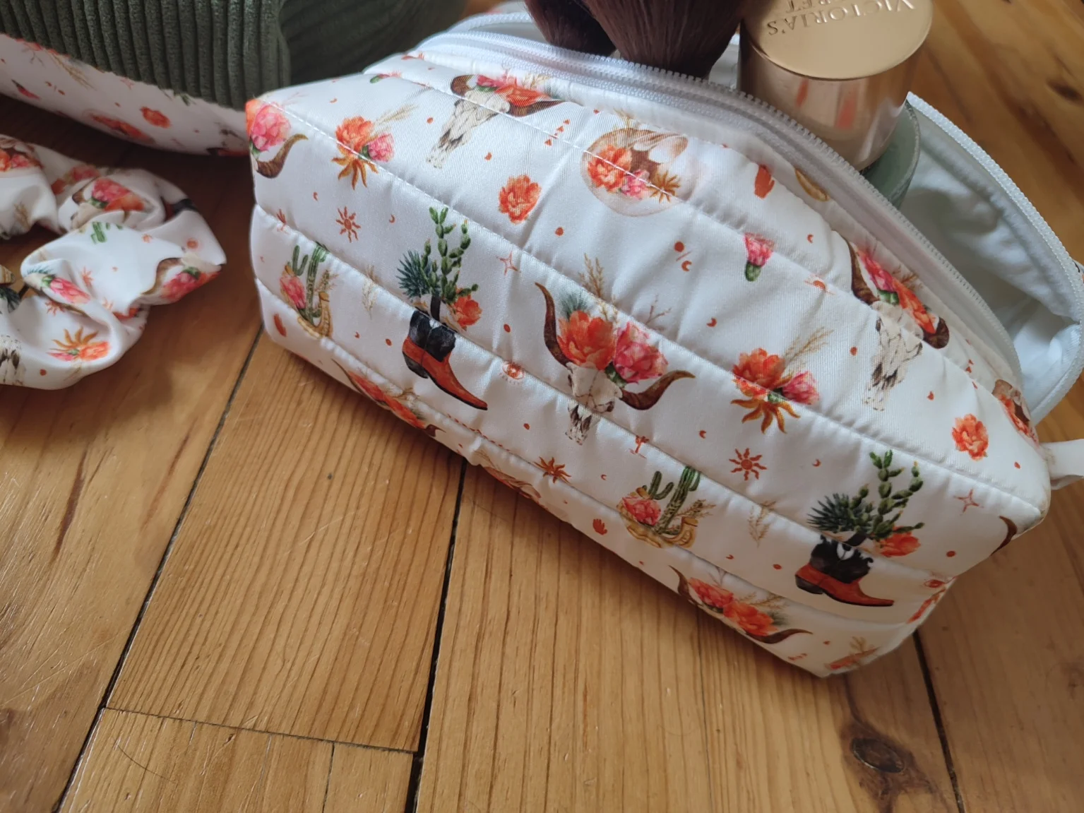 trousse de toilette Fleurs de l'ouest fait main avec un tissus un tissus avec des cactus, des bottes de cowboys, des chapeaux de cowboys et des tête de buffle tête de mort sur fond blanc