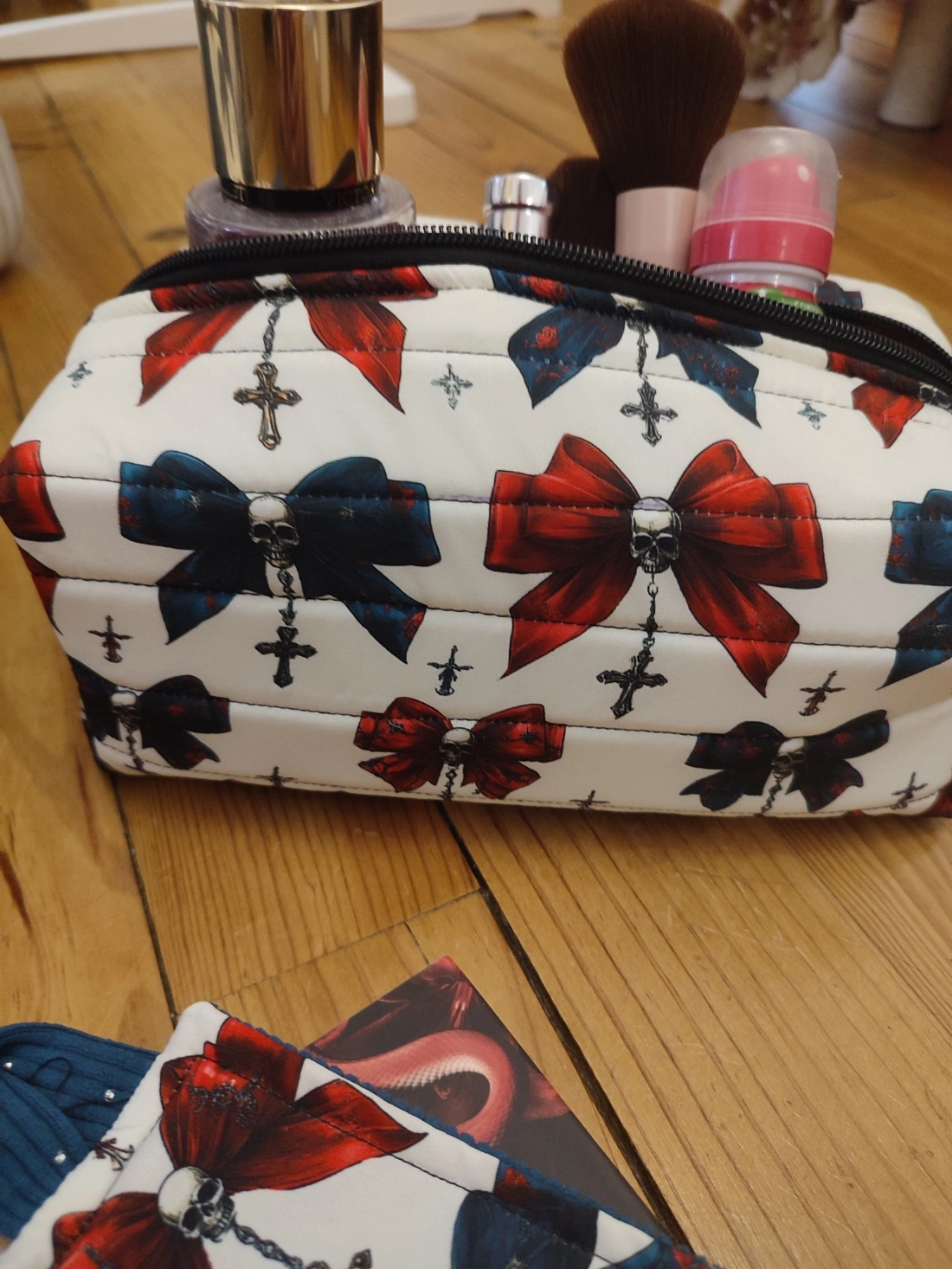 Trousse de toilette Nuit de velours fait main avec un tissus avec des têtes de mort, des noeuds de couleurs rouge et colvert sur fond blanc