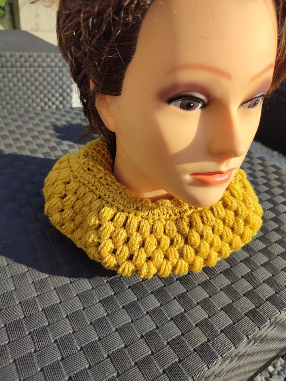 Cache-cou de couleur moutarde sur une tête de mannequin