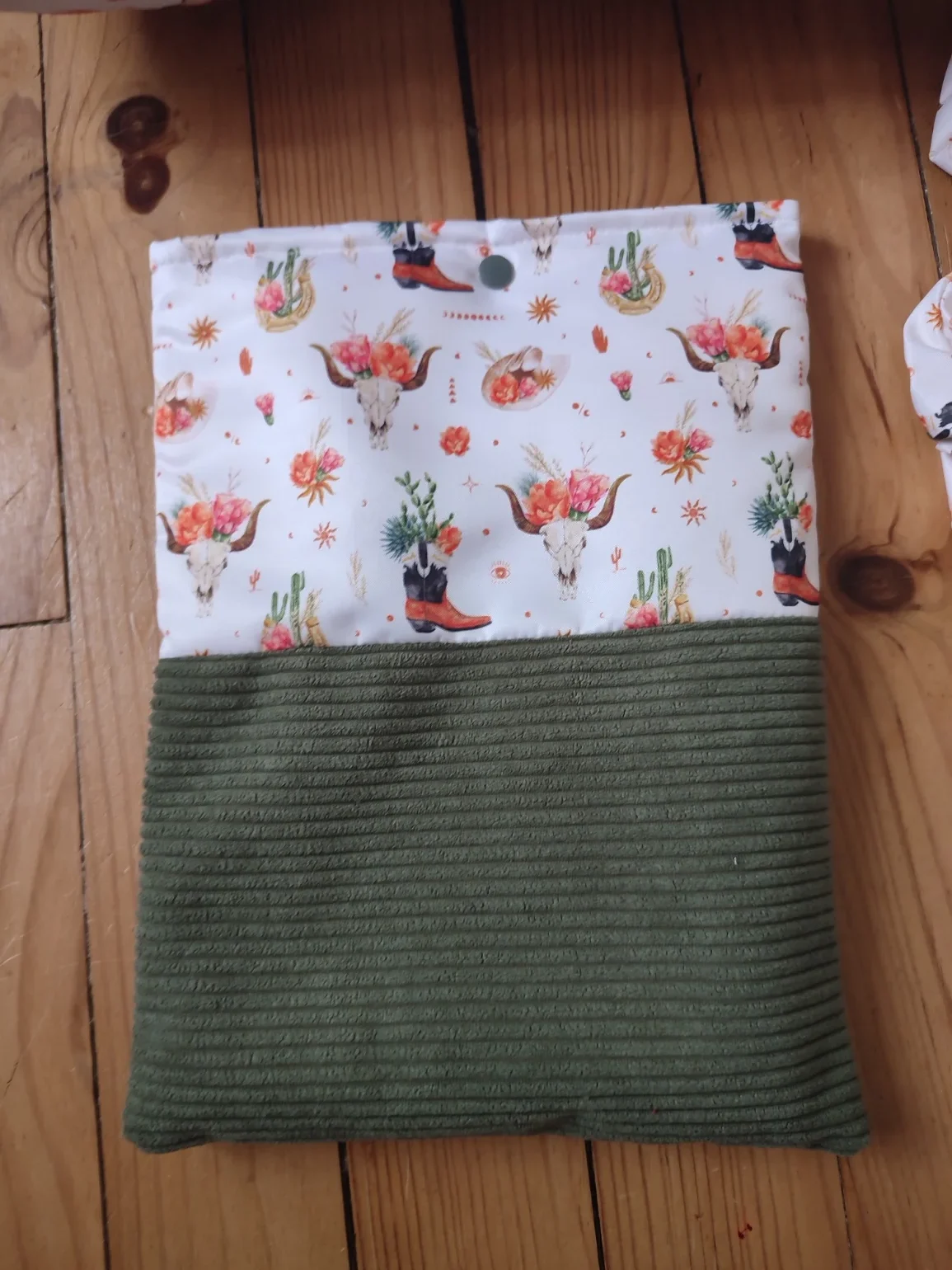 Pochette à livre Fleurs de l'ouest fait main avec un tissus côtelé de couleur vert et un tissus avec des cactus, des bottes de cowboys, des chapeaux de cowboys et des tête de buffle tête de mort sur fond blanc
