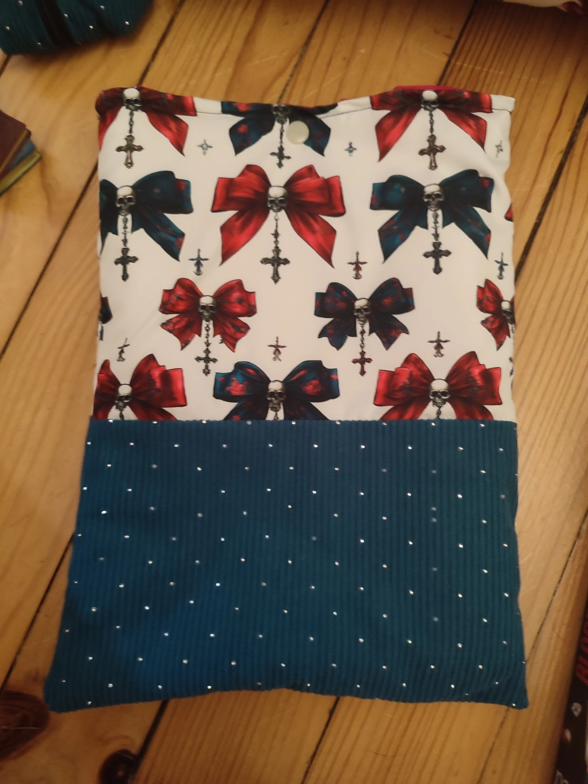 Pochette à livre Nuit de velours fait main avec un tissus côtelé de couleur colvert et un tissus avec des têtes de mort, des noeuds de couleurs rouge et colvert sur fond blanc
