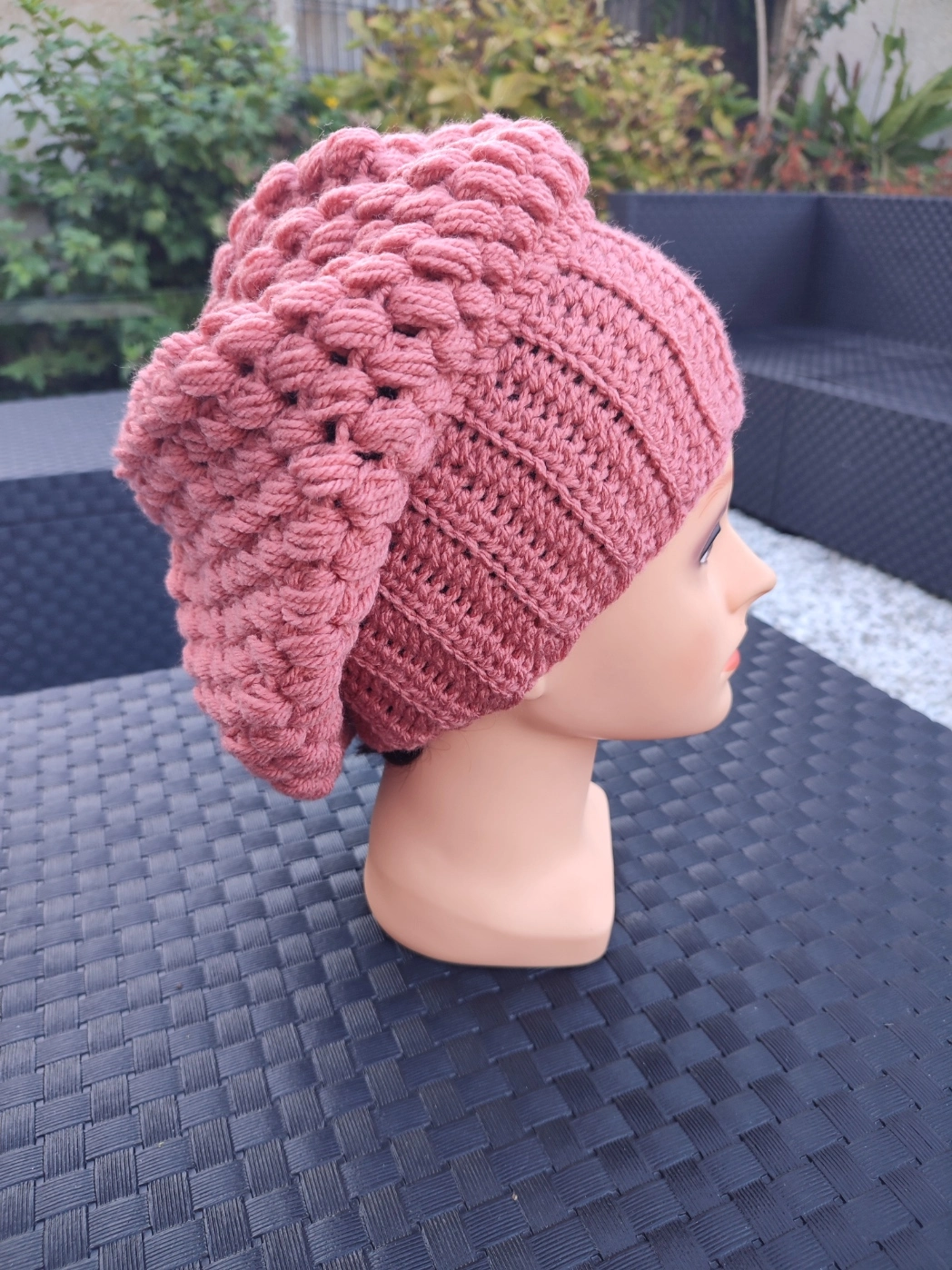 bonnet retombant fait main en crochet de couleur terracotta sur une tête de mannequin