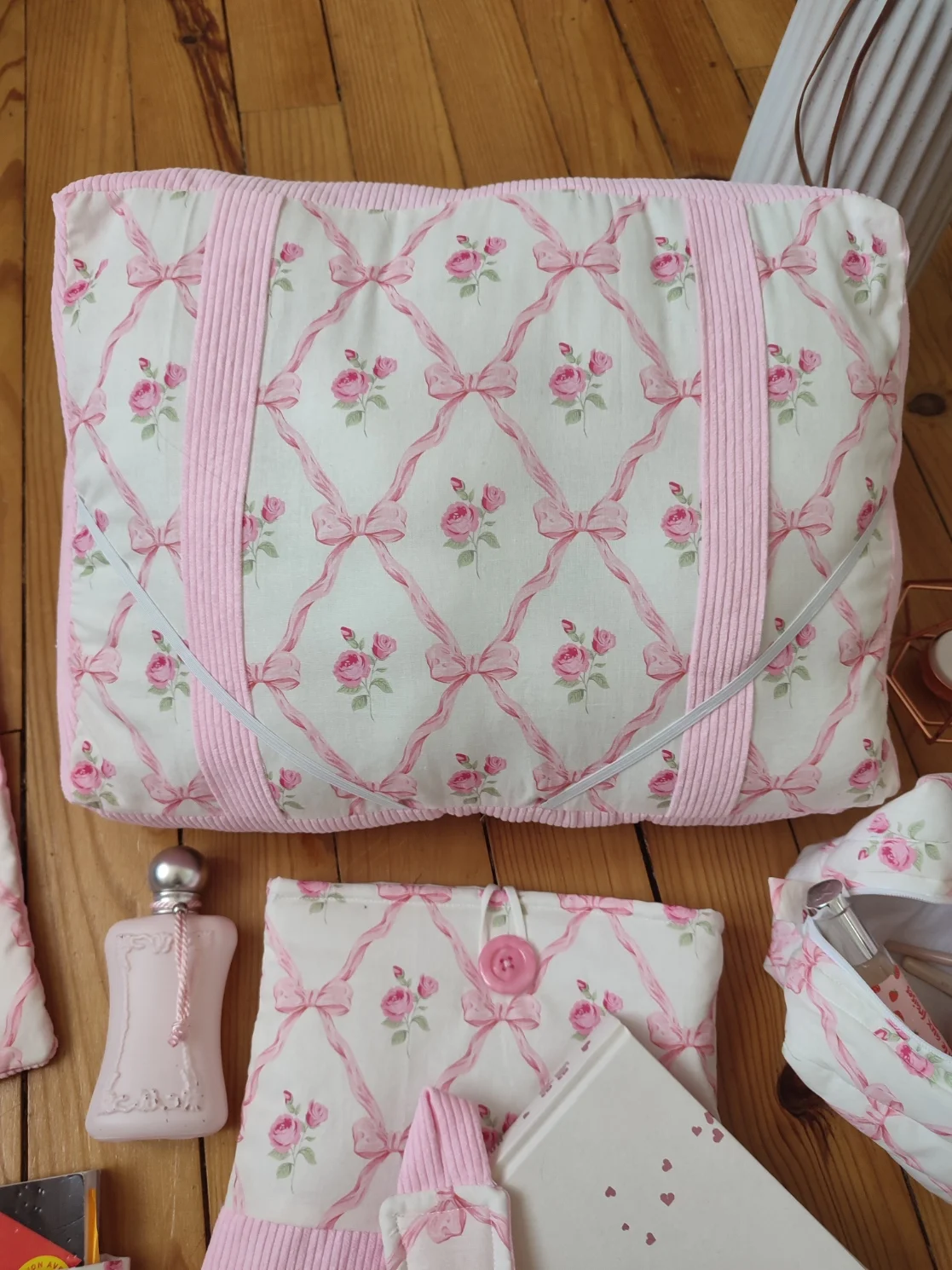 Coussin de lecture ruban rose fait main avec un tissus représentant des noeuds rose et des rose fushia sur fond bland et un tissus côtelé rose