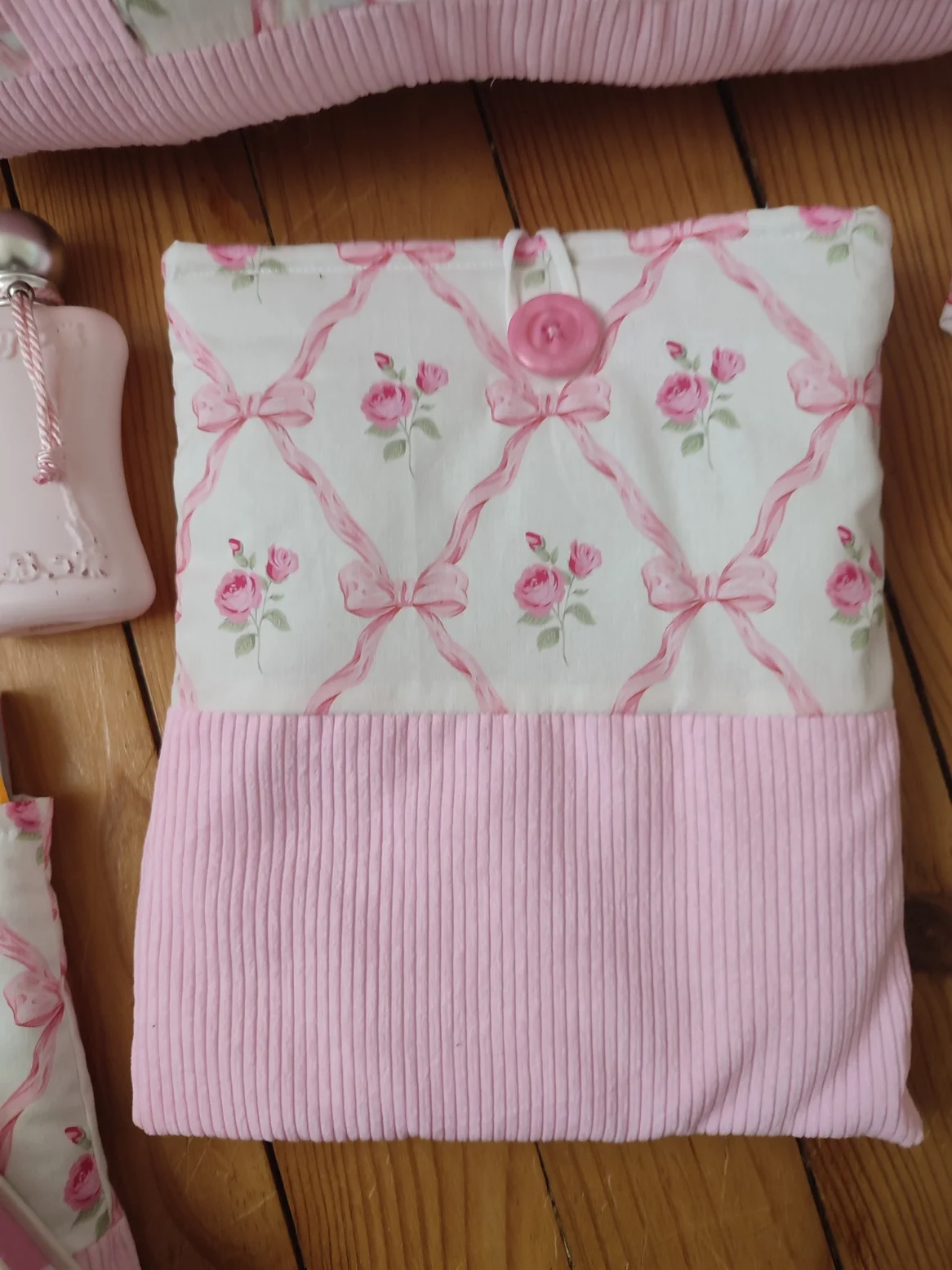 Pochette à livre ruban rose fait main avec un tissus représentant des noeuds rose et des rose fushia sur fond bland et un tissus côtelé rose
